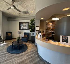 Reception desk and lounge area with seating and plants
