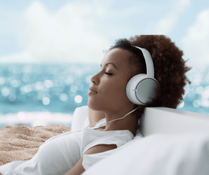 Woman relaxing with headphones on beach — calm and stress-free